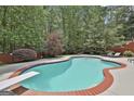 Relaxing backyard pool with a diving board, surrounded by mature trees, offering privacy and a serene atmosphere at 602 Embassy Ct, Peachtree City, GA 30269