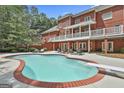 Enjoy the outdoors with this pool surrounded by a brick patio perfect for entertaining and relaxation at 602 Embassy Ct, Peachtree City, GA 30269