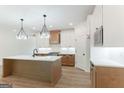 Modern kitchen boasts an island, stainless steel appliances, and stylish pendant lighting at 4731 H D Atha Rd, Covington, GA 30014