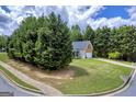 Residential home on a corner lot with lush surrounding trees and well-maintained lawn at 4985 Rolling Rock Dr., Sugar Hill, GA 30518