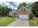 Attractive single-Gathering home with brick facade, well-maintained lawn, and attached two-car garage at 4985 Rolling Rock Dr., Sugar Hill, GA 30518