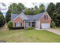 Charming single-story home featuring a lush green lawn, brick accents, and a two-car garage at 4985 Rolling Rock Dr., Sugar Hill, GA 30518