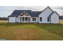 Expansive backyard featuring a modern farmhouse with a covered porch at 4751 H D Atha Rd, Covington, GA 30014