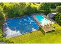 Aerial view of the community pool, playground, and basketball court, surrounded by lush green trees and landscaping at 205 N Strathmore Dr, Sharpsburg, GA 30277