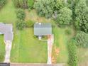 Aerial view of a home featuring a green shingled roof, a driveway, and lush surrounding greenery at 140 Joshua St, Palmetto, GA 30268