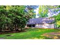Large, grassy backyard surrounded by mature trees, featuring a screened-in porch, perfect for outdoor enjoyment at 530 Austin Dr, Mcdonough, GA 30252