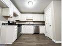 Well-lit kitchen with white cabinets, stainless steel appliances, and dark countertops, providing a modern touch at 530 Austin Dr, Mcdonough, GA 30252