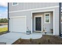 Close up of townhome entrance and garage featuring black door and welcome sign at 109 Feeney Lane, Villa Rica, GA 30180