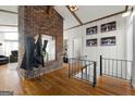 A stylish foyer featuring wood floors, a brick accent wall, and an adjacent living area at 405 Miller Rd, Covington, GA 30014