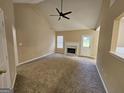 Bright living room with a vaulted ceiling, a ceiling fan, a fireplace, and neutral carpet at 3081 Regal Dr, Mcdonough, GA 30253
