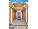 Covered front porch features brick siding, a concrete floor, and a charming entry door at 418 Crosshaven Way, Mcdonough, GA 30253