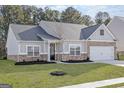 Inviting home showcasing a well-maintained front yard and a classic mix of siding and brick architectural details at 3734 Saddle Bag Ct, Dacula, GA 30019