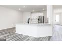 Bright, open kitchen featuring a large island, stainless steel appliances, and sleek white cabinetry at 3734 Saddle Bag Ct, Dacula, GA 30019