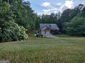 View of home from across expansive front lawn, with mature landscaping and mature trees at 57 Deer Creek Run, Moreland, GA 30259