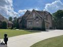 A well-maintained driveway leads to a brick home with an attached garage and landscaped front yard at 2220 Cambridge Hill Ct, Dacula, GA 30019