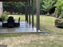Covered patio with outdoor seating and views of the well-maintained backyard and landscaping at 2220 Cambridge Hill Ct, Dacula, GA 30019