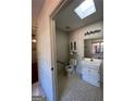Bright bathroom featuring a skylight, white vanity, toilet and shower with white brick accent wall at 363 Seminole Drs, Marietta, GA 30060