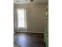 Neutral bedroom featuring a window with blinds and curtains, hardwood floor, and green dresser at 4230 Vinca Way, Union City, GA 30291