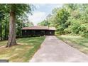 A charming single story home with a covered porch and long driveway surrounded by lush trees at 134 Ashwood Dr, Waco, GA 30182