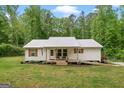 Quaint one-story home with a metal roof, wooden shutters, and a welcoming front porch at 180 E Ranchette Rd, Temple, GA 30179