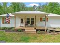Inviting home featuring a covered front porch with rocking chairs and wood accents at 180 E Ranchette Rd, Temple, GA 30179