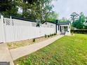 Exterior view showcasing a charming home and white fence, set amidst a serene landscape at 2502 Barge Sw Rd, Atlanta, GA 30331