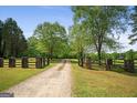 Long gravel driveway leading up to the property, with gated entrance and sprawling greenery at 9511 High Point Rd, Villa Rica, GA 30180