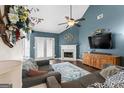 Inviting living room with vaulted ceilings, fireplace, ceiling fan, and cozy seating area at 308 Dylan Way, Mcdonough, GA 30252