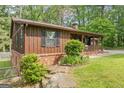 The side of this charming home features updated landscaping and a brick foundation at 6537 Walker Rd, Riverdale, GA 30296