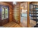 Inviting foyer featuring wood paneling, stylish flooring, and a view into the kitchen with a spiral staircase at 1597 Leguin Mill Rd, Locust Grove, GA 30248