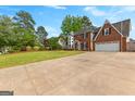 Spacious front yard and long driveway leading to a two-story brick home, perfect for families at 317 Calgary Dr, Peachtree City, GA 30269