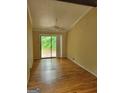 Bright living room featuring wood floors and sliding glass doors leading to an outdoor deck at 5128 Running Fox Trl, Norcross, GA 30071