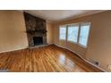 Living room with wood floors, a stone fireplace and a bay window at 5128 Running Fox Trl, Norcross, GA 30071