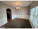 Traditional dining room featuring a chandelier, wainscoting, neutral walls, and large window at 6206 Flat Trace, South Fulton, GA 30291
