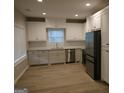 Modern kitchen featuring white cabinets, stainless steel appliances, granite countertops and luxury vinyl flooring at 320 Sharon Dr # A & B, Fayetteville, GA 30214