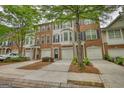 Exterior view of brick townhomes featuring attached garages and well-maintained landscaping in a residential area at 2160 Dillard Xing, Tucker, GA 30084