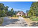 Expansive estate home with a circular driveway and beautifully landscaped grounds, framed by mature trees at 7523 Kimberly Lynn Ct, Lithonia, GA 30058