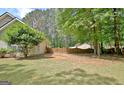 Spacious backyard featuring a private wooden fence and mature trees, perfect for outdoor activities at 15 Riverside Pkwy, Sharpsburg, GA 30277