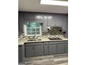 Kitchen features gray cabinets, granite countertops, stainless steel appliances, and decorative tile backsplash at 554 Windsor Dr, Forest Park, GA 30297