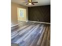 Open-concept living room boasts stylish gray floors and a decorative accent wall with geometric designs at 554 Windsor Dr, Forest Park, GA 30297
