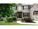 Beautiful brick home with well-manicured landscaping and a welcoming front entrance at 5760 Winding Lakes Dr, Cumming, GA 30028