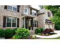 Well-maintained home featuring brick and stone accents, dark shutters, and manicured landscaping at 5760 Winding Lakes Dr, Cumming, GA 30028