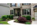 Charming brick home with a covered porch and landscaped front yard at 5760 Winding Lakes Dr, Cumming, GA 30028