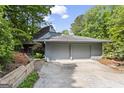 Exterior shot of home with attached garage and lush surrounding greenery at 3863 Dundee Ne Dr, Roswell, GA 30075