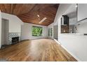 Bright living room featuring a skylight, fireplace, and scenic backyard view at 3863 Dundee Ne Dr, Roswell, GA 30075