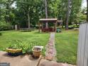 Spacious backyard featuring a stone-paved walkway leading to an outdoor gazebo, surrounded by mature trees and lush greenery at 3969 W Hilda Cir, Decatur, GA 30035