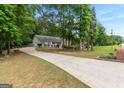 Spacious driveway leading to a lovely home surrounded by lush greenery and mature trees at 372 River Point Dr, Mcdonough, GA 30252