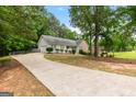 Well-maintained home featuring a long driveway and lush front yard with mature trees at 372 River Point Dr, Mcdonough, GA 30252