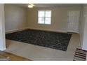 Bright and airy living room featuring neutral carpet and a large window at 56-1 N East Main St, Hampton, GA 30228