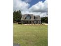 Well-manicured lawn leads up to this beautiful two story home, under a partly cloudy sky at 808 Covered Bridge Rd, Covington, GA 30016